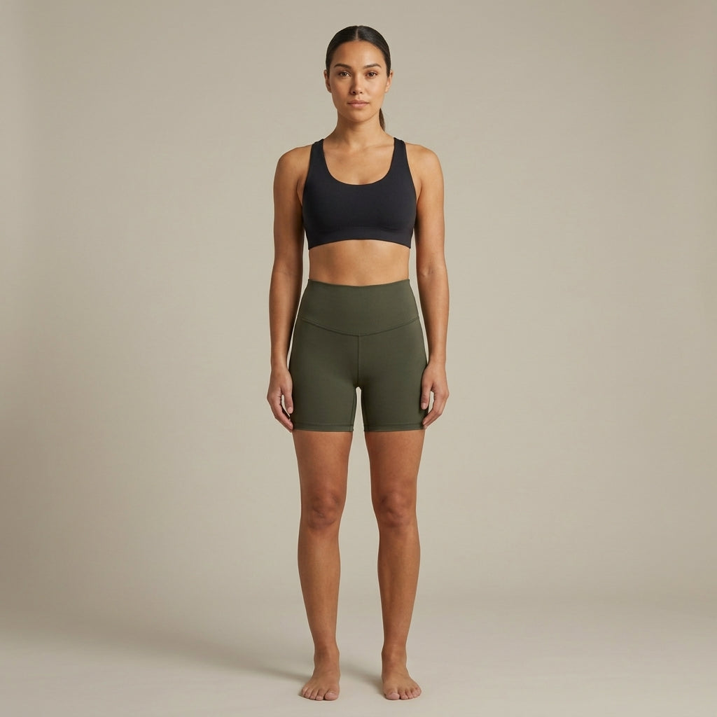 Short seamless taille haute kaki vu de face, porté par une femme pieds nus