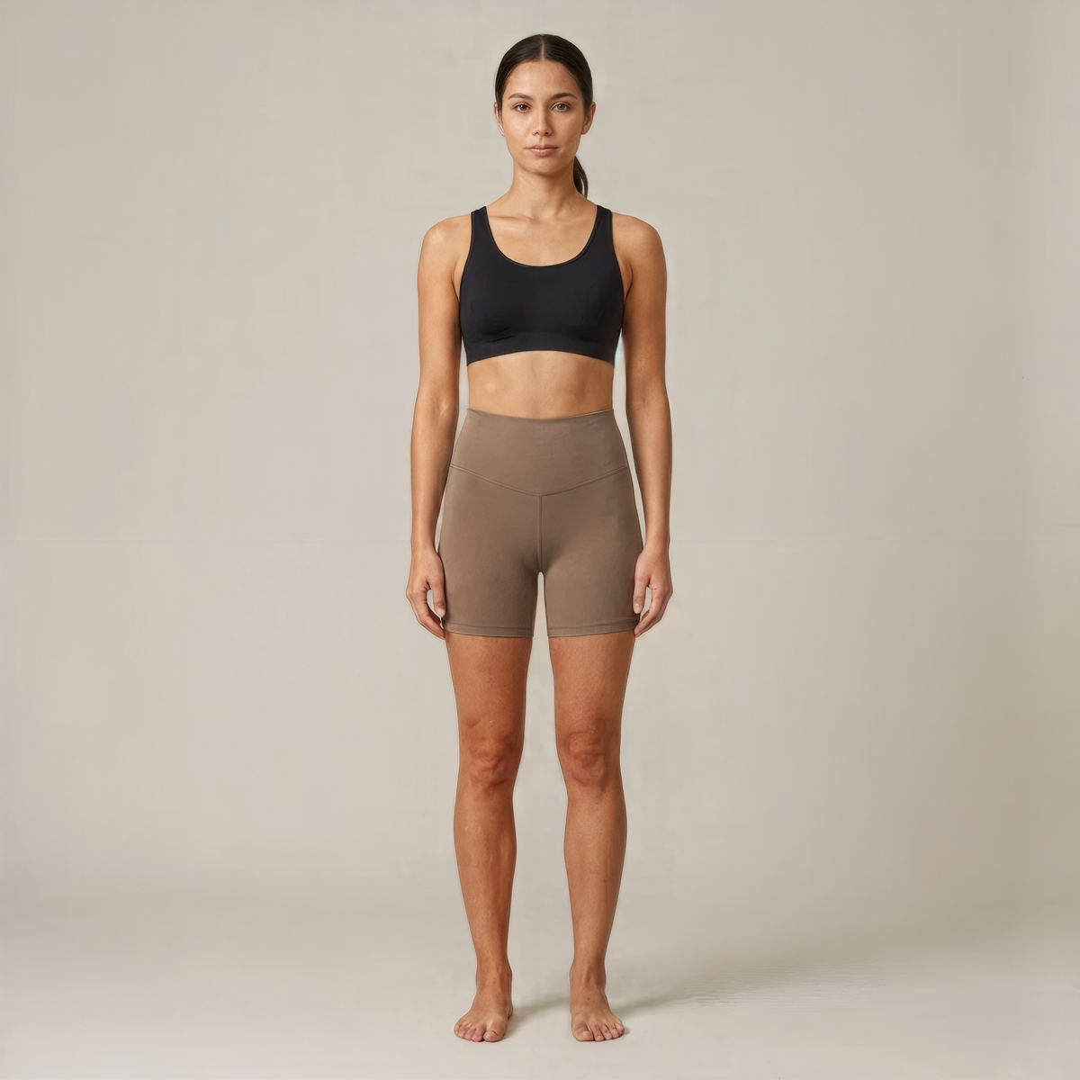 Short seamless taille haute sable vu de face, porté par une femme pieds nus